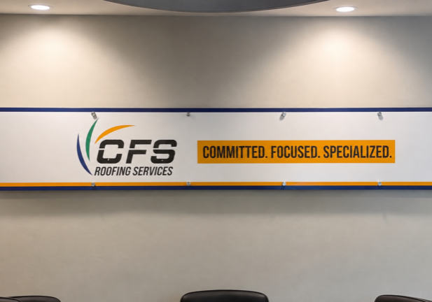 Custom CFS Roofing Services lobby sign installed in a Cape Coral meeting room with professional branded graphics.